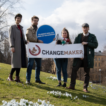 Kuvassa Changemakereitä kukkulalla Changemaker-banderolli ja syrjinnästä vapaa alue -kyltti kädessään.